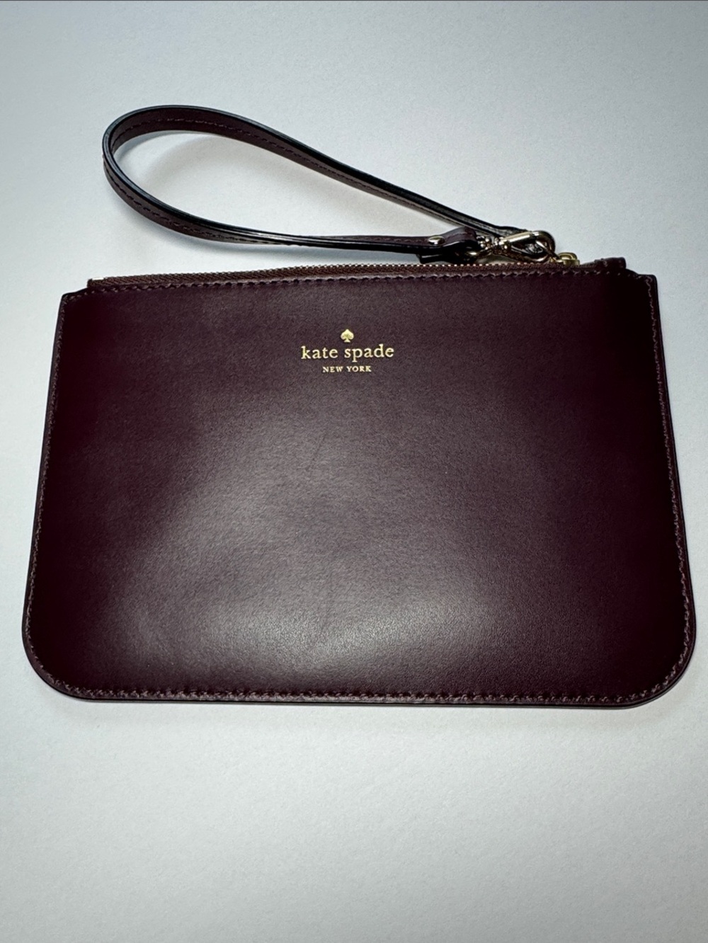 kate spade Burgundy leather wristlet with gold logo - Like New